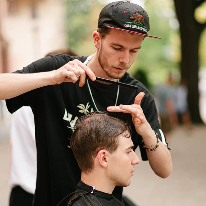 Justin Murray schneidet Kunden im Freien die Haare, gestützt durch die Effizienz von Paymash, was ihm mehr Zeit für sein Handwerk gibt.